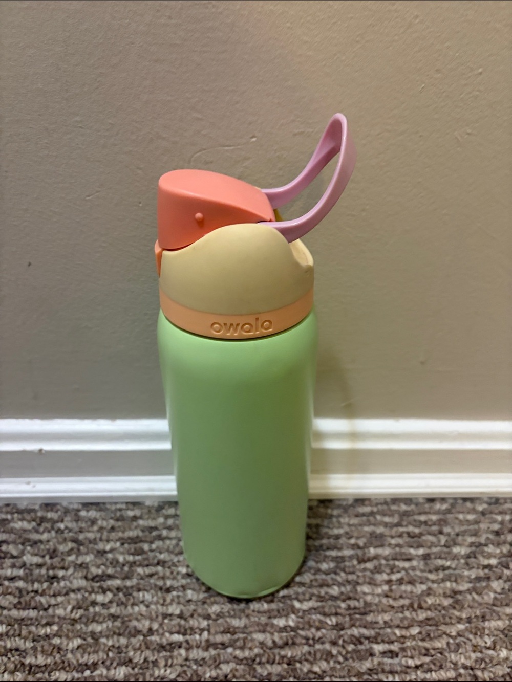 Owala pastel green water bottle with peach, yellow and pink lid accents